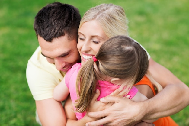 família, felicidade, adoção e conceito de pessoas - família feliz abraçando ao ar livre