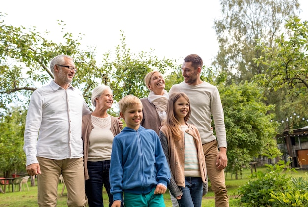 Família, felicidade, geração, lar e conceito de pessoas - família feliz em frente à casa ao ar livre