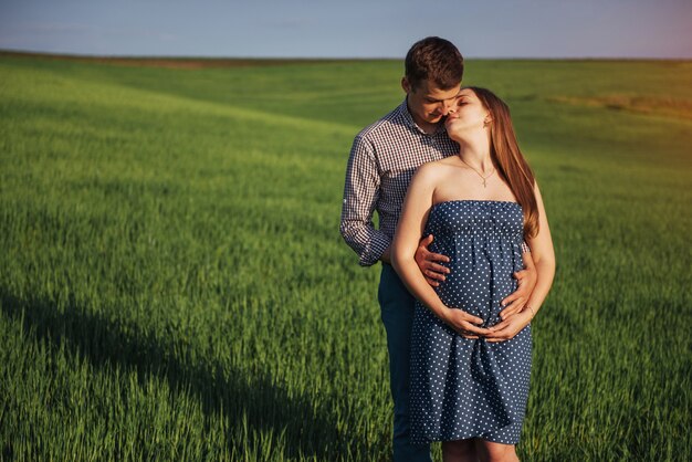 Família feliz, abraçando em um campo de trigo verde