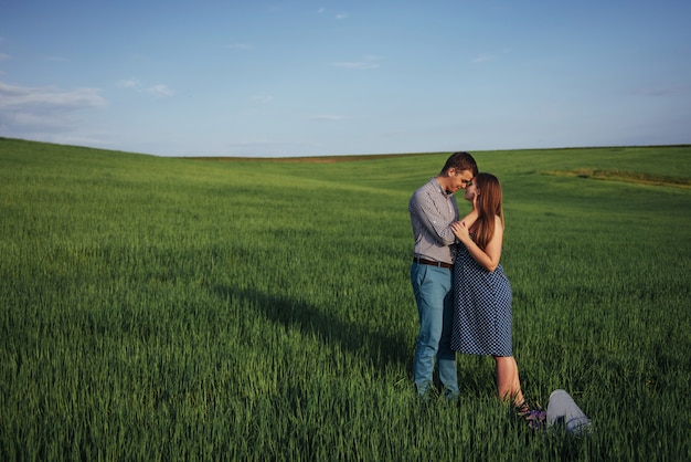 Familia feliz abrazando en un campo de trigo verde