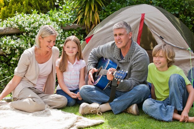 Família feliz acampando no jardim