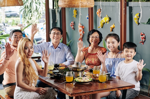 Família feliz acenando com as mãos