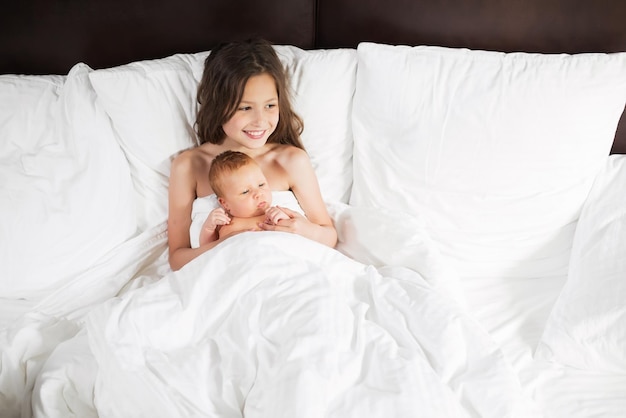 Familia feliz acostada bajo una manta en la cama en casa