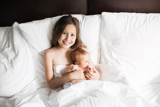 Familia feliz acostada bajo una manta en la cama en casa