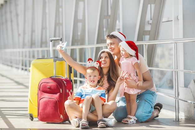 Familia feliz en el aeropuerto con equipaje