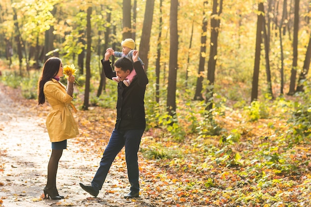 Familia feliz al aire libre en otoño. Bebé y madre y padre