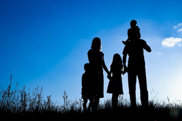 Foto familia feliz al aire libre en la silueta del parque