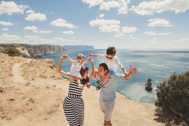 Família feliz andando nas montanhas à beira-mar