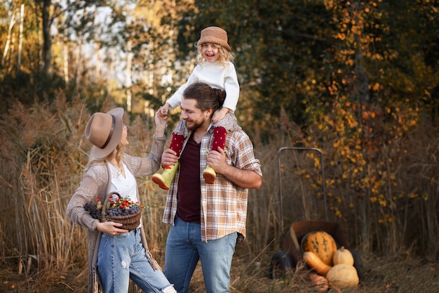 Família feliz ao lado de um monte de abóboras