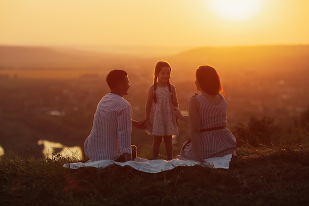 Família feliz ao pôr do sol incrível