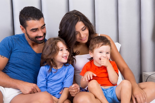 Família feliz aproveitando a manhã na cama