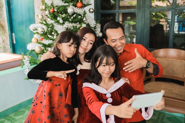 Familia feliz asiática celebrando la Navidad juntos en casa