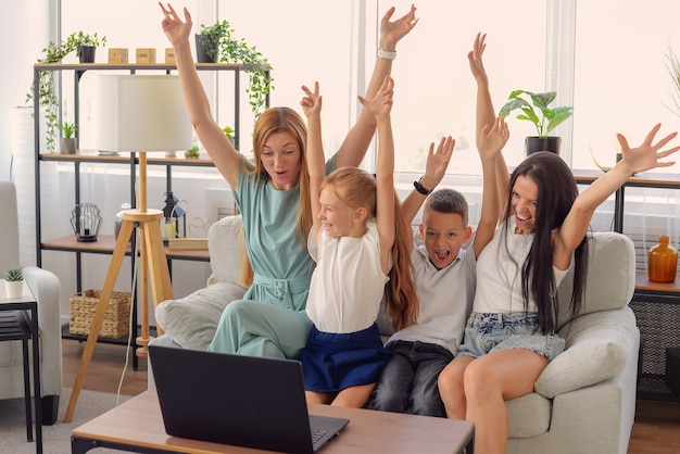 família feliz assistindo filme juntos no laptop em casa felizes juntos