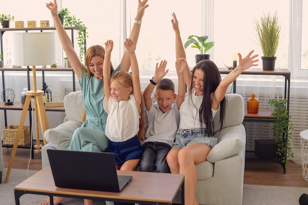 Família feliz assistindo filme juntos no laptop em casa felizes juntos