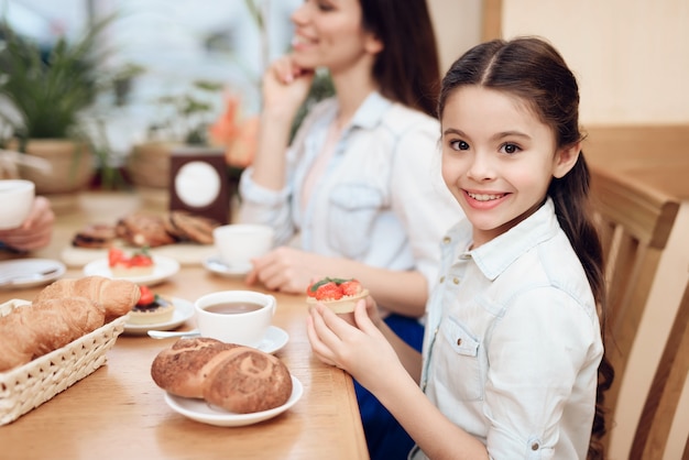 Família feliz bem comendo bolos na cafetaria.