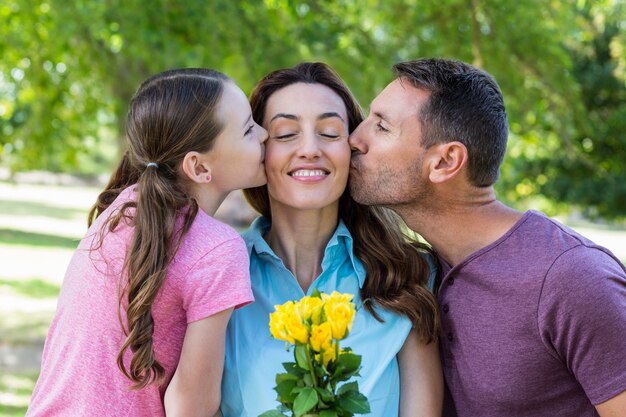 Familia feliz besando a la cámara en el parque