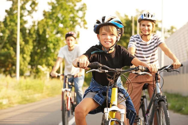 Familia feliz en bicicleta al aire libre