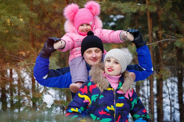 Familia feliz en el bosque de invierno. pasar tiempo al aire libre en invierno