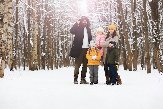 Família feliz brincando e rindo no inverno ao ar livre na neve. Dia de inverno do Parque da cidade.