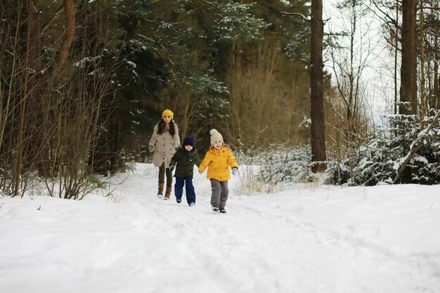 Família feliz brincando e rindo no inverno ao ar livre na neve. Dia de inverno do Parque da cidade.