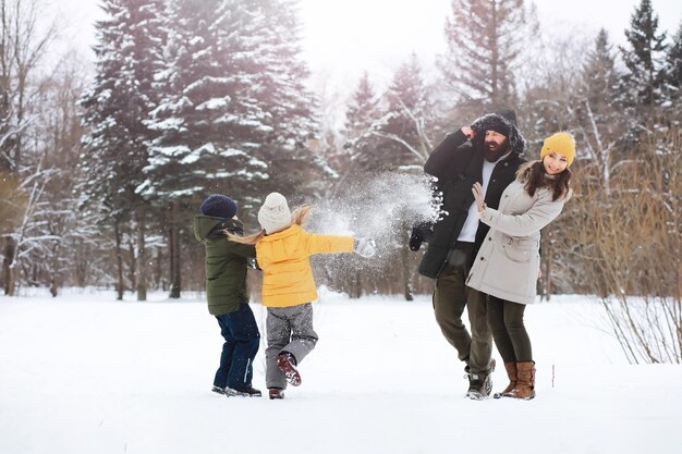 Família feliz brincando e rindo no inverno ao ar livre na neve. Dia de inverno do Parque da cidade.