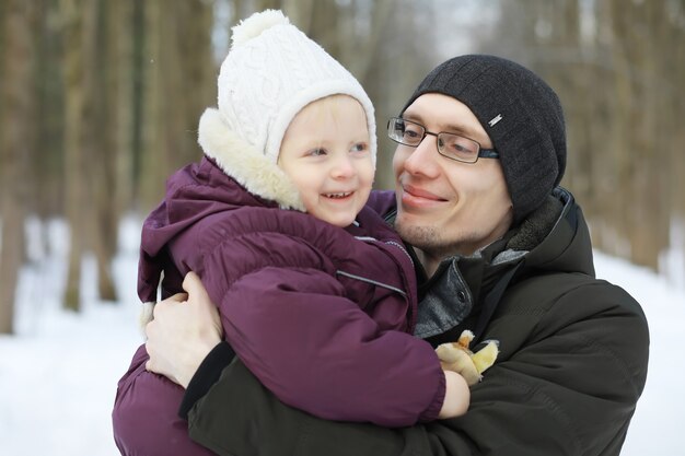 Família feliz brincando e rindo no inverno ao ar livre na neve. Dia de inverno do Parque da cidade.