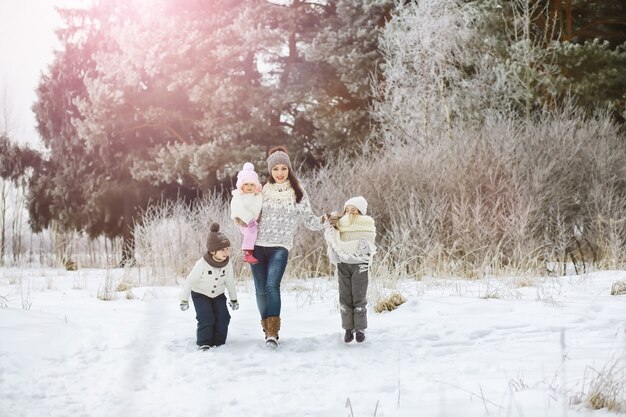 Família feliz brincando e rindo no inverno ao ar livre na neve. Dia de inverno do Parque da cidade.