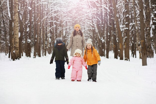 Família feliz brincando e rindo no inverno ao ar livre na neve. Dia de inverno do parque da cidade.