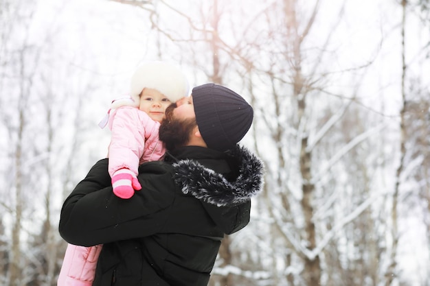 Família feliz brincando e rindo no inverno ao ar livre na neve. Dia de inverno do parque da cidade.