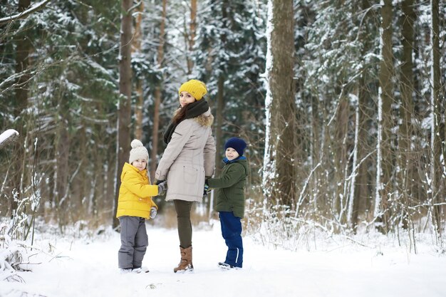 Família feliz brincando e rindo no inverno ao ar livre na neve. Dia de inverno do parque da cidade.