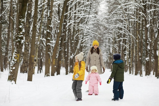 Família feliz brincando e rindo no inverno ao ar livre na neve. Dia de inverno do parque da cidade.