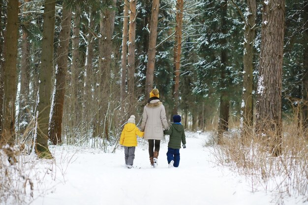 Família feliz brincando e rindo no inverno ao ar livre na neve. Dia de inverno do parque da cidade.