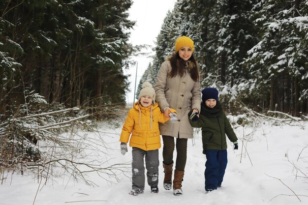 Família feliz brincando e rindo no inverno ao ar livre na neve. Dia de inverno do parque da cidade.