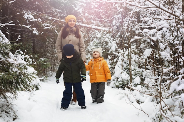 Família feliz brincando e rindo no inverno ao ar livre na neve. Dia de inverno do parque da cidade.