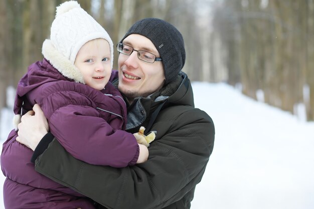 Família feliz brincando e rindo no inverno ao ar livre na neve. Dia de inverno do Parque da cidade.