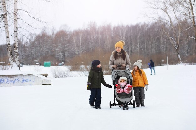 Família feliz brincando e rindo no inverno ao ar livre na neve. dia de inverno do parque da cidade.