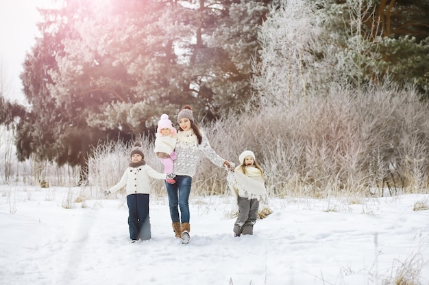 Família feliz brincando e rindo no inverno ao ar livre na neve. Dia de inverno do Parque da cidade.