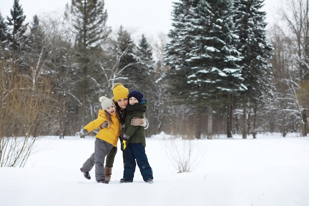 Família feliz brincando e rindo no inverno ao ar livre na neve. Dia de inverno do Parque da cidade.