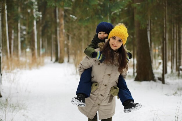 Família feliz brincando e rindo no inverno ao ar livre no dia de inverno do parque da cidade de neve