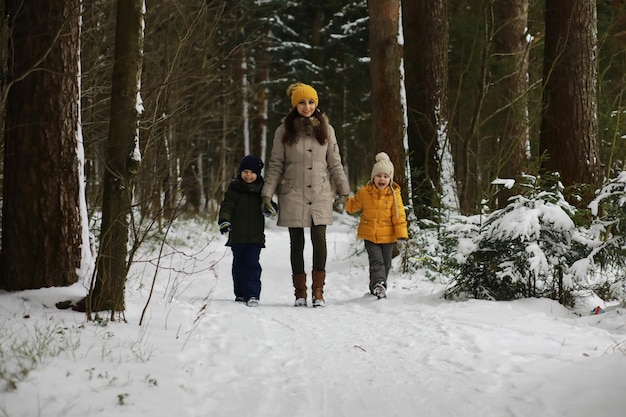 Família feliz brincando e rindo no inverno ao ar livre no dia de inverno do parque da cidade de neve