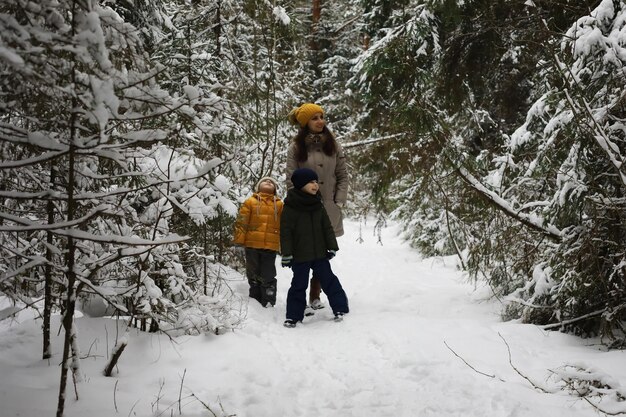 Família feliz brincando e rindo no inverno ao ar livre no dia de inverno do parque da cidade de neve