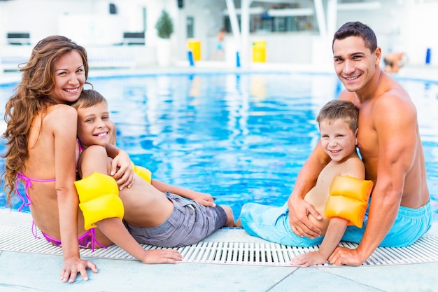 Família feliz brincando na piscina. Conceito de férias de verão