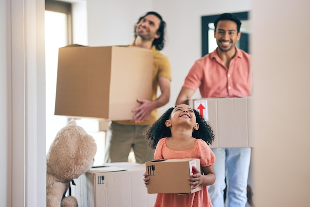 Foto familia feliz y caja moviéndose con niños y padres homosexuales en un nuevo hogar con paquete de cartón sonríe a niños y personas lgbt junto con bienes raíces e hipotecas de propiedad en una casa ayudando a padre