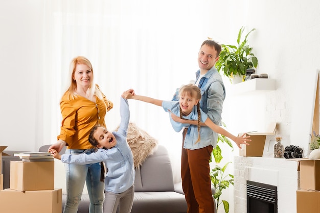 Familia feliz con cajas de cartón en casa nueva en el día de la mudanza.