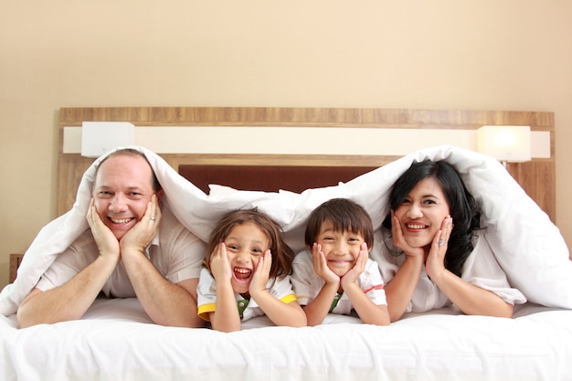 Familia feliz en la cama