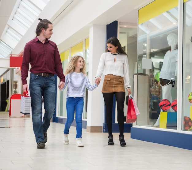 Familia feliz caminando con bolsas de compras