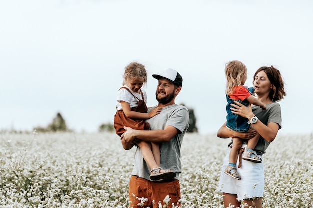 Familia feliz caminando en el campo, jugando y disfrutando el día de verano. Concepto de estilo de vida