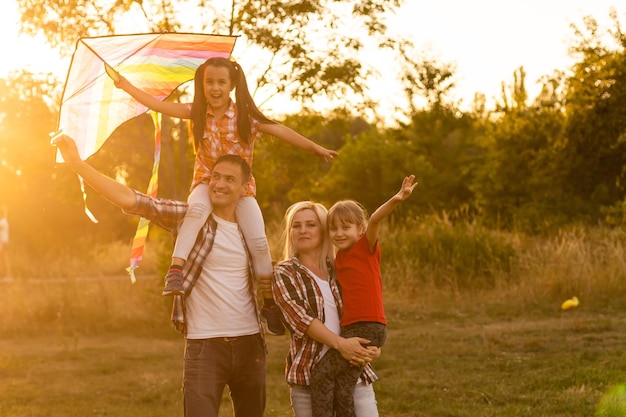 Familia feliz caminando en el campo y mirando al atardecer