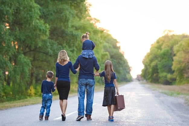 Una familia feliz caminando por la carretera en el parque en un viaje por la naturaleza