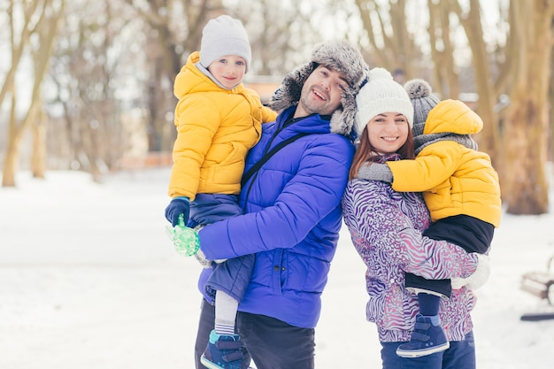 Familia feliz caminando juntos en Winter Park, dos hombres y mujeres adultos y dos niños